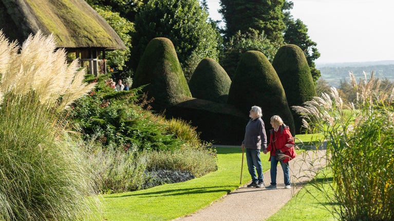 Visitors exploring the autumn colours in the garden pass the Hawk House at Chirk Castle and Garden, Wrexham.